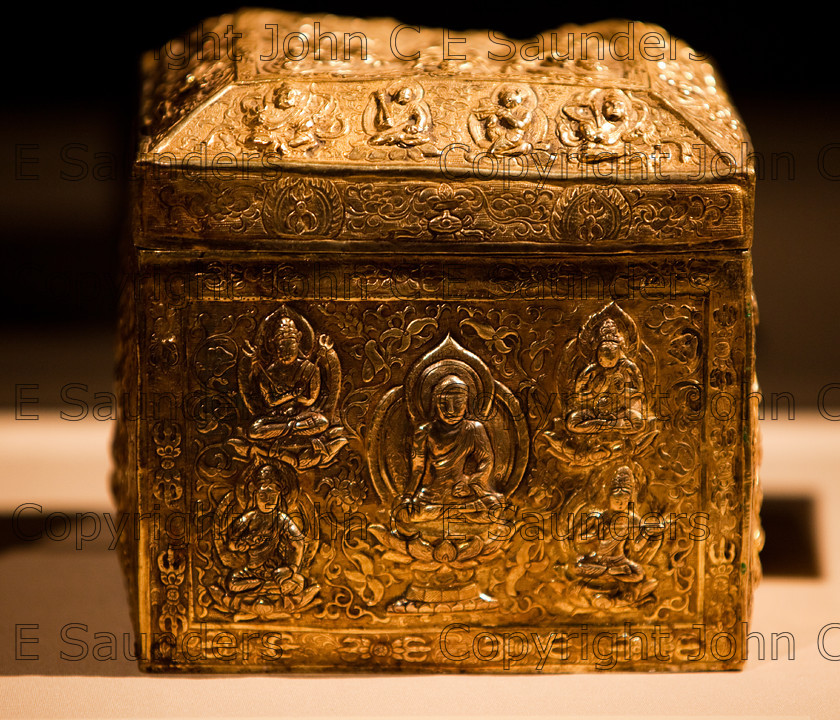 IMG 2786 
 Ancient Chinese gold treasure or funerary urn from the Tang dynasty (618 - 907CE), with intricate decorative side and lid showing seated emperor and buddhas. 
 Keywords: Tang, ancient, art, box, casket, chinese, cube, decorated, dynasy, gold, hand made, precious, shadows, shiny, square, treasure, urn