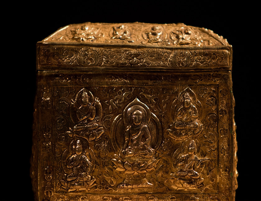IMG 2782 
 Ancient Chinese gold treasure or funerary urn from the Tang dynasty (618 - 907CE), with intricate decorative side and lid showing seated emperor and buddhas. 
 Keywords: Tang, ancient, art, box, casket, chinese, cube, decorated, dynasy, gold, hand made, precious, shadows, shiny, square, treasure, urn
